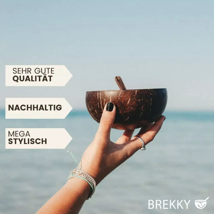 Brekky Bowl Hand hält Kokosnussschale am Meer